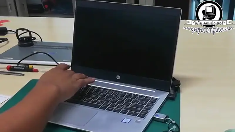 โน้ตบุ๊ค HP บนโต๊ะซ่อมพร้อมอุปกรณ์